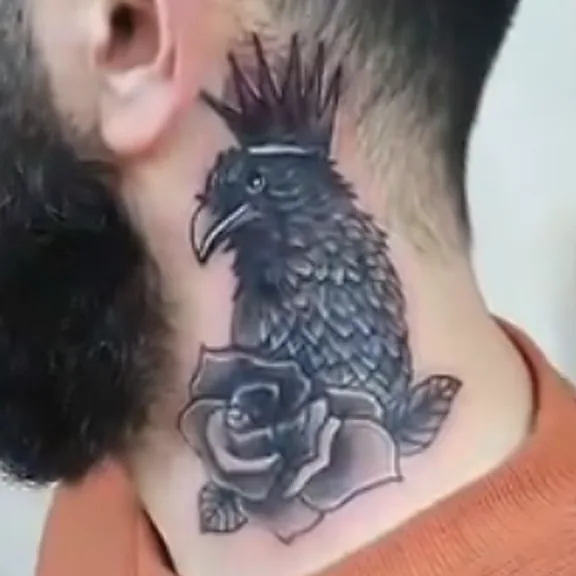 Boyunda dövme kapatma, önce: eski tabanca dövmesi; sonra: güle tünemiş taçlı kuzgun – Semih Art Tattoo, Bursa